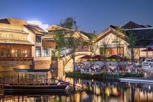 a restaurant with a boat in the water next to buildings at lyf by Ascott Hongqiao Shanghai NECC in Shanghai