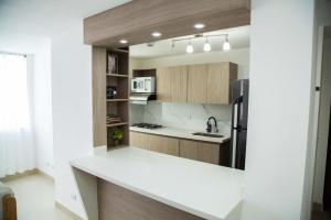 uma cozinha com um balcão branco e um frigorífico em Magnífico Apartamento amoblado Medellín em Bello