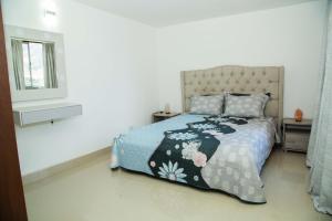 um quarto com uma cama com colcha floral e uma janela em Magnífico Apartamento amoblado Medellín em Bello