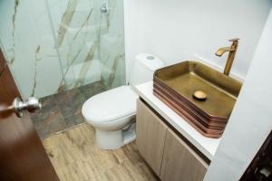 a bathroom with a toilet and a sink at Magnífico Apartamento amoblado Medellín in Bello