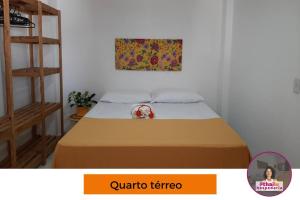 uma cama num quarto com uma fotografia na parede em Casa 5km Praia Coroa Vermelha 1 quarto no Térreo em Santa Cruz Cabrália