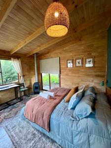 1 dormitorio con 1 cama grande en una habitación de madera en Siempre Verde en Puerto Tranquilo