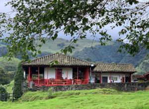 a house on a hill with mountains in the background at Hostal La Laguna in Villamaría