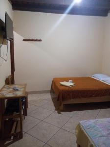 Habitación con cama, mesa y escritorio. en Hospedaje Flores, en Nazca