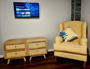 a living room with a tv and a chair and a dresser at Jasmine Escape - WITH SPA, home in heart of Hunter in Ellalong