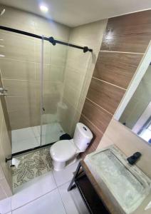 a bathroom with a toilet and a glass shower at Lindo Apartamento central Ibague in Ibagué