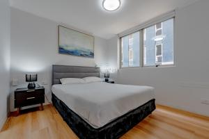 um quarto com uma cama grande e 2 janelas em Abbey On Roma Hotel & Apartments em Brisbane