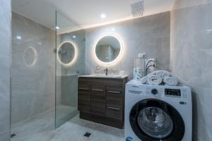 a bathroom with a washing machine and a shower at Abbey On Roma Hotel & Apartments in Brisbane