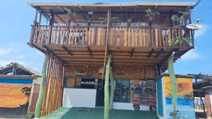 um edifício de madeira com uma varanda em cima em Hotel Gabarra Lodge em San Vicente