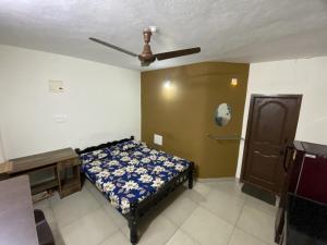 a bedroom with a bed and a ceiling fan at Charming guesthouse in heart of Manipal in Manipala