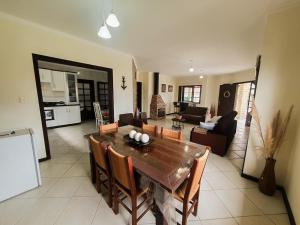 a dining room and living room with a table and chairs at CENTRO DE XANGRI-LÁ COM PISCINA in Xangri-lá