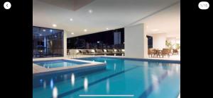 a swimming pool in a building with a view of the city at Flat Boulevard Side 2104 Altissimo Padrão com Lazer in Salvador