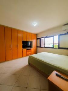 a bedroom with a bed and cabinets and a microwave at CENTRO DE XANGRI-LÁ COM PISCINA in Xangri-lá