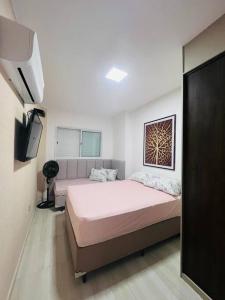 大普拉亚AP Elegante e luxuoso no Caiçara的一间卧室，配有两张床和一台平板电视 更多22张照片