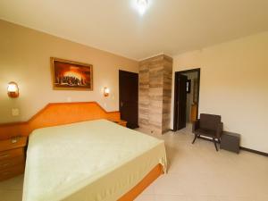 a bedroom with a bed and a chair in it at CENTRO DE XANGRI-LÁ COM PISCINA in Xangri-lá +19 photos
