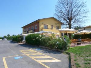 ブッソレンゴにあるLe Colline del Gardaの駐車場のテーブルと傘のある建物