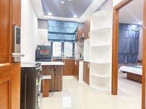 a kitchen with white shelves and a bed at Milanesa Hotel and Apartment in Vung Tau