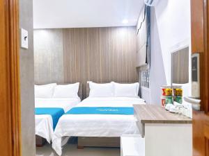 a hotel room with two beds and a table at Milanesa Hotel and Apartment in Vung Tau