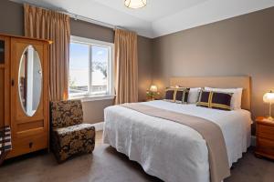 Un dormitorio con una cama grande y una ventana en Homelea Bed and Breakfast, en Christchurch