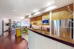 a large kitchen with wooden cabinets and stainless steel appliances at Pearl At Jackson #203 in Jackson