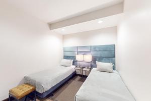 two beds in a room with white walls at Pearl At Jackson #203 in Jackson