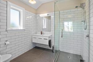 a white bathroom with a sink and a shower at Homelea Bed and Breakfast in Christchurch