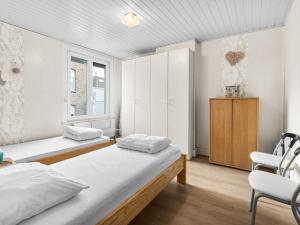 um quarto com duas camas e uma cadeira. em Van Mullemstraat 15 2 bedrooms on floor 2 em Blankenberge