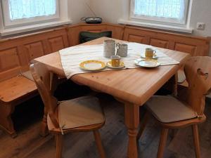 einem Holztisch mit zwei Tassen und Tellern darauf in der Unterkunft Nice holiday home in Hochgallmigg with terrace in Hochgallmig