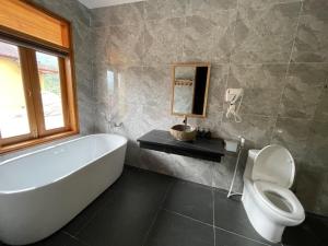 a bathroom with a tub and a toilet and a sink at Sky Bay Ha Giang in Ha Giang