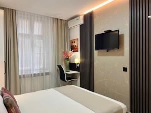 a hotel room with a bed and a tv on the wall at Centar Forever in Belgrade
