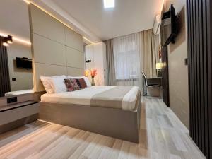 a bedroom with a large bed and a television at Centar Forever in Belgrade