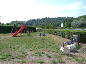 un parque con parque infantil con tobogán y banco en Le Colline del Garda en Bussolengo