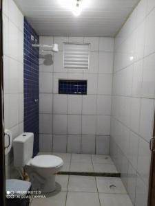 - wyłożoną kafelkami łazienkę z toaletą i oknem w obiekcie Recanto do Pontal Camping w mieście Angra dos Reis