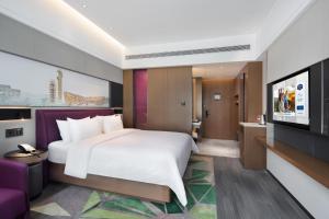 a bedroom with a large bed and a flat screen tv at Hampton by Hilton Beijing South Railway Station in Beijing