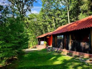a house with a red roof in a forest at Rancho San Miguel in Villa del Carbón
