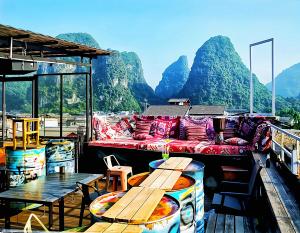 a couch on a boat with mountains in the background at Showbiz Hostel in Yangshuo