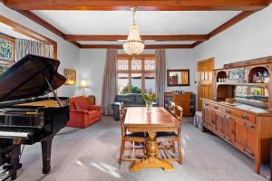 - un salon avec un piano et une table dans l'établissement Homelea Bed and Breakfast, à Christchurch