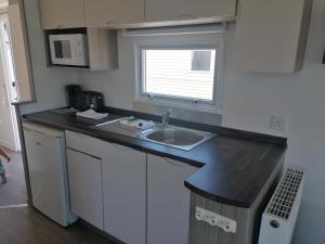 a small kitchen with a sink and a window at Seaside Delight - Close to the beach in Kent