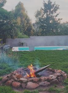 una hoguera en un patio junto a una piscina en Guayaquil Hospedaje en Tandil