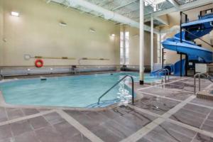 a swimming pool with a slide in a building at Chic Mountain View - Pool&HotTub - Fireplace - BBQ! in Canmore