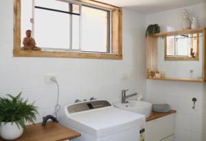 a white bathroom with a sink and a window at Surf Shack in Iconic Rainbow Bay - Coolangatta QLD (pet friendly) in Gold Coast