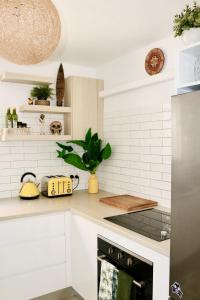 a white kitchen with a black stove top oven at Surf Shack in Iconic Rainbow Bay - Coolangatta QLD (pet friendly) in Gold Coast