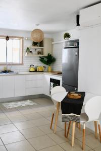 a kitchen with white cabinets and a table and chairs at Surf Shack in Iconic Rainbow Bay - Coolangatta QLD (pet friendly) in Gold Coast