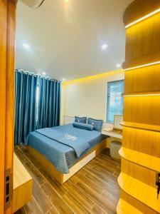 a bedroom with a bed with blue sheets and a window at Ocean Villa Novaworld Phan Thiết in Bình Tú