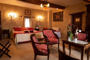 a bedroom with a bed and a table and chairs at Le Clos des Courtines - Les 4 Vents in Meuvaines