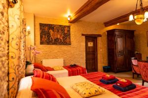 a bedroom with two beds and a painting on the wall at Le Clos des Courtines - Meuvaines in Meuvaines