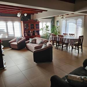 a living room with couches and a table and chairs at Casa de familia in Ushuaia