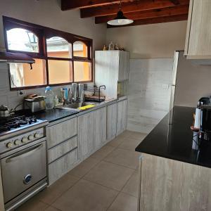 uma grande cozinha com um fogão e um lavatório em Casa de familia em Ushuaia