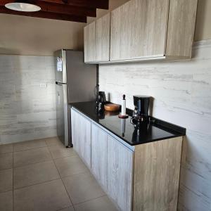 eine Küche mit einer schwarzen Arbeitsplatte und einem Kühlschrank in der Unterkunft Casa de familia in Ushuaia