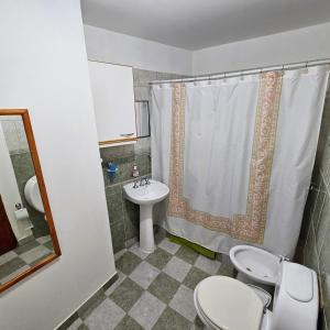 ein Bad mit einem WC, einem Waschbecken und einer Dusche in der Unterkunft Casa de familia in Ushuaia